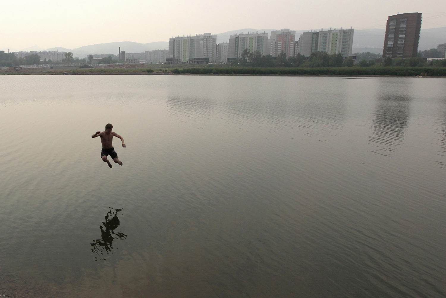 мужчина прыгает в воду